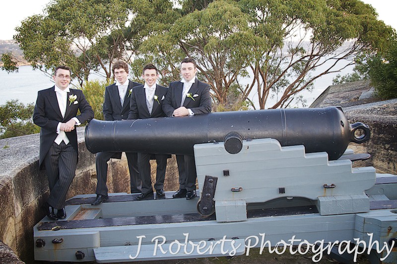 Groom and groomsmen leaning on the historic canons at Georges Headland Mosman - wedding photography sydney